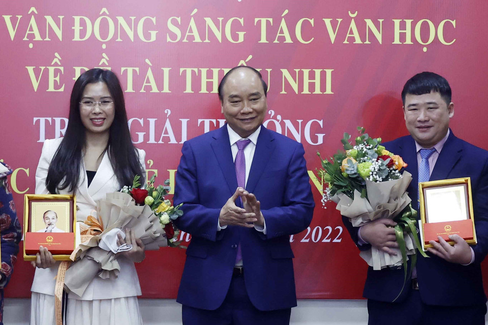 Chủ tịch nước Nguyễn Xuân Phúc tặng chân dung Chủ tịch Hồ Chí Minh cho các tác giả trẻ. (Ảnh: Thống Nhất/TTXVN)