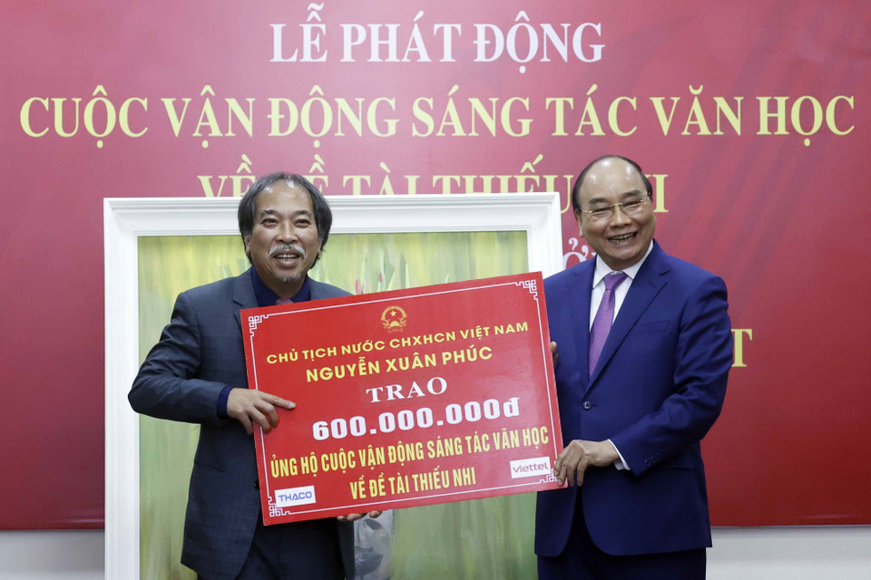 Chủ tịch nước Nguyễn Xuân Phúc trao tặng 600 triệu đồng ủng hộ cuộc vận động sáng tác văn học về đề tài thiếu nhi. (Ảnh: Thống Nhất/TTXVN)