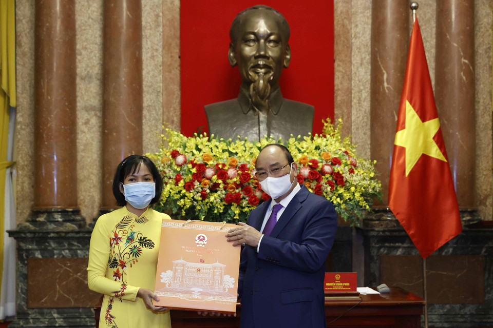 Chủ tịch nước Nguyễn Xuân Phúc tặng quà cho cán bộ y tế tiêu biểu toàn quốc. (Ảnh: Thống Nhất/TTXVN)