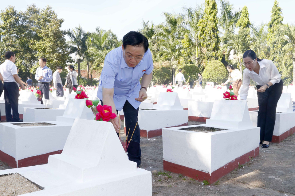 Chủ tịch Quốc hội Vương Đình Huệ thắp hương tại mộ phần của các liệt sỹ. (Ảnh: Doãn Tấn/TTXVN)
