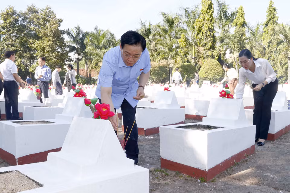Chủ tịch Quốc hội Vương Đình Huệ thắp hương tại mộ phần của các liệt sỹ. (Ảnh: Doãn Tấn/TTXVN)
