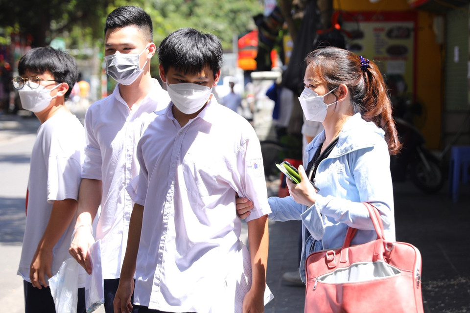 Phụ huynh đón con em dưới thời tiết nắng nóng. (Ảnh: Hoàng Hiếu/TTXVN)