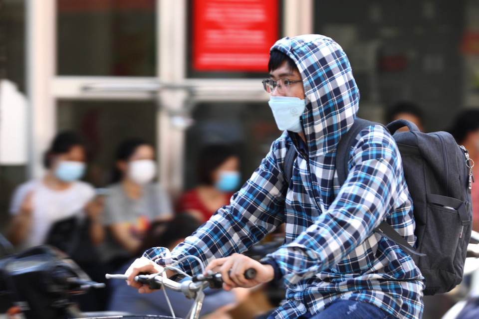 Người dân sử dụng quần áo tránh nắng, nóng khi phải di chuyển ngoài trời. (Ảnh: Hoàng Hiếu/TTXVN)