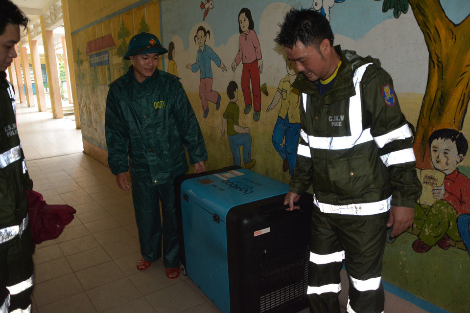 Lực lượng chức năng phường Mân Thái chuyển máy phát điện đến tại điểm sơ tán trường Tiểu học Quang Trung. (Ảnh: Văn Dũng/TTXVN)