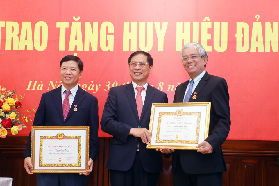 Bộ trưởng Bộ Ngoại giao Bùi Thanh Sơn trao Huy hiệu 30 năm tuổi Đảng tặng nguyên Thứ trưởng Bộ Ngoại giao: Phạm Quang Vinh và Nguyễn Quốc Cường (trái).(Ảnh: Lâm Khánh/TTXVN)