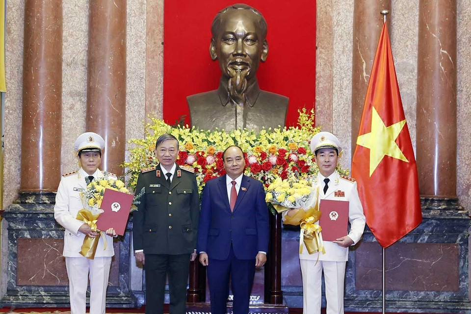 Chủ tịch nước Nguyễn Xuân Phúc trao Quyết định thăng cấp bậc hàm từ Trung tướng lên Thượng tướng đối với Thứ trưởng Bộ Công an Trần Quốc Tỏ và Lương Tam Quang.(Ảnh: Thống Nhất/TTXVN)