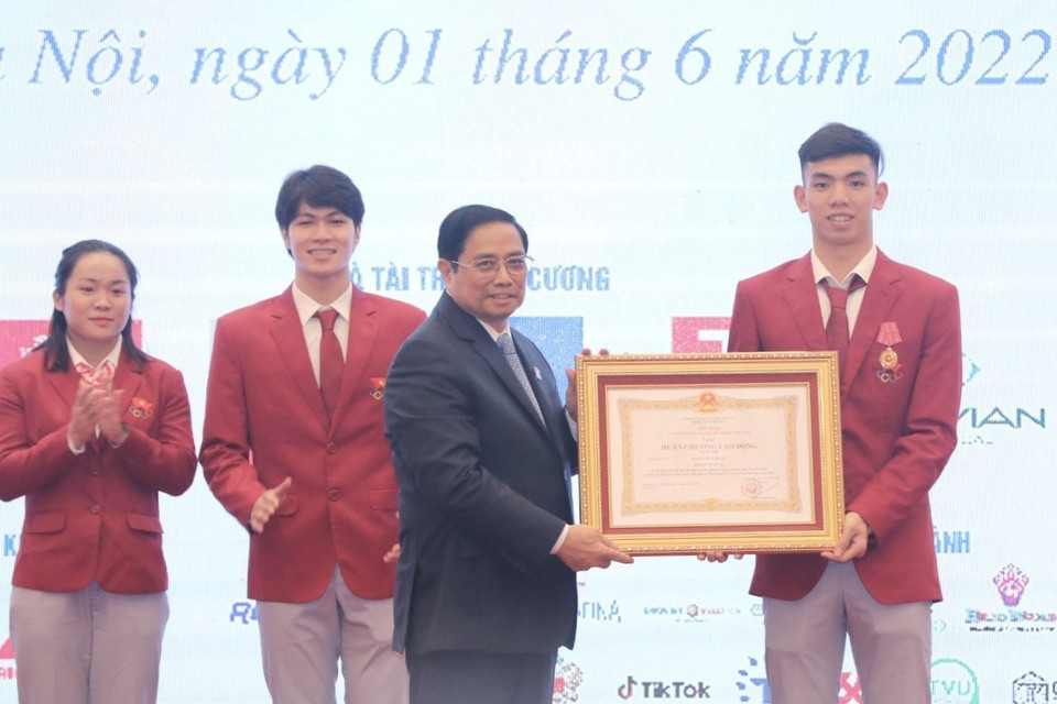 Thủ tướng Chính phủ Phạm Minh Chính trao Huân chương Lao động hạng Nhì cho vận động viên Nguyễn Huy Hoàng (bơi). (Ảnh: Minh Quyết/TTXVN)