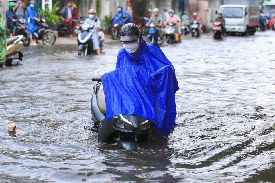 Người dân dắt phương tiện chết máy trên đường Tô Ngọc Vân - Thành phố Thủ Đức. (Ảnh: Hồng Giang/TTXVN)