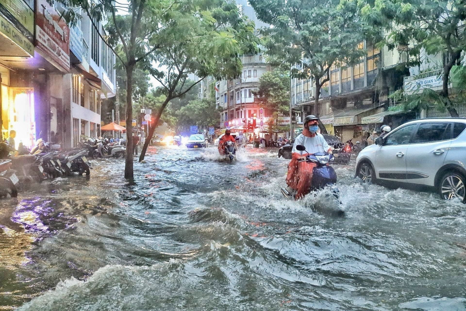 Người dân di chuyển giữa 'biển nước' trên đường Phạm Ngũ Lão - Quận 1. (Ảnh: Hồng Giang/TTXVN)