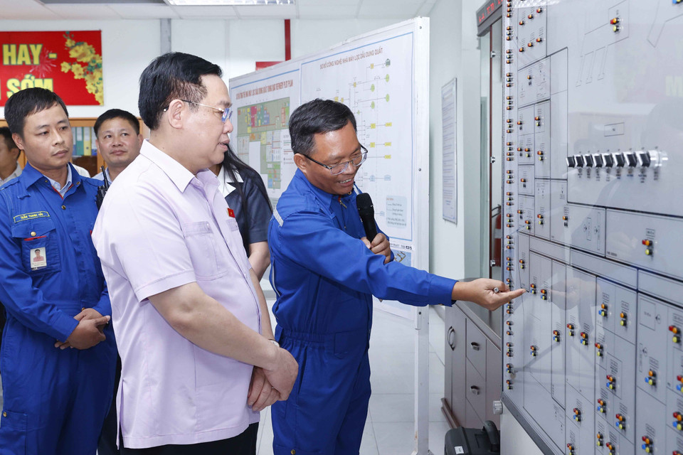 Chủ tịch Quốc hội Vương Đình Huệ nghe giới thiệu về sơ đồ tổng thể Nhà máy lọc dầu Dung Quất tại Phòng điều khiển Trung tâm. (Ảnh: Doãn Tấn/TTXVN)