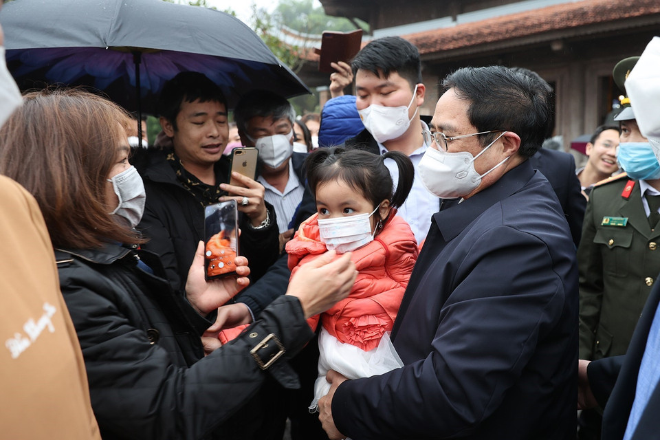 Thủ tướng Phạm Minh Chính trò chuyện với người dân đang du Xuân đón Tết tại Khu Di tích Kim Liên. (Ảnh: Dương Giang/TTXVN)