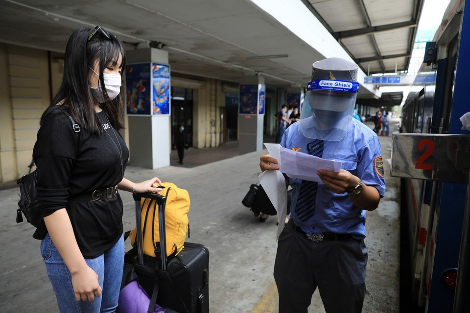 Nhân viên Ga Hà Nội kiểm tra vé và chỗ ngồi cho du khách. (Ảnh: Thành Đạt/TTXVN)