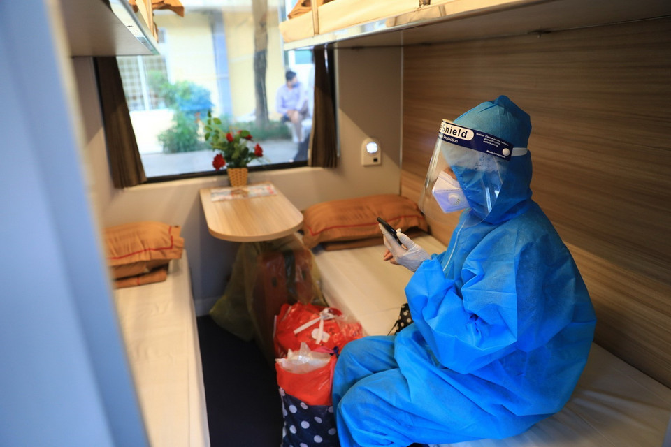 Một số hành khách cẩn thận mặc đồ bảo hộ phòng dịch khi lên tàu. (Ảnh: Thành Đạt/TTXVN)