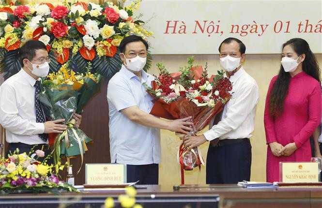 Chủ tịch Quốc hội Vương Đình Huệ trao nghị quyết và tặng hoa chúc mừng lãnh đạo Viện Nghiên cứu lập pháp. (Ảnh: Doãn Tấn/TTXVN)