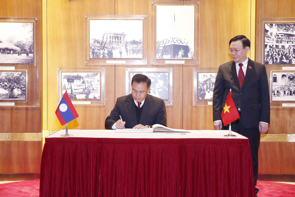 Chủ tịch Quốc hội Lào Xaysomphone Phomvihane ký Sổ vàng tại Phòng truyền thống của Quốc hội Việt Nam. (Ảnh: Doãn Tấn/TTXVN)