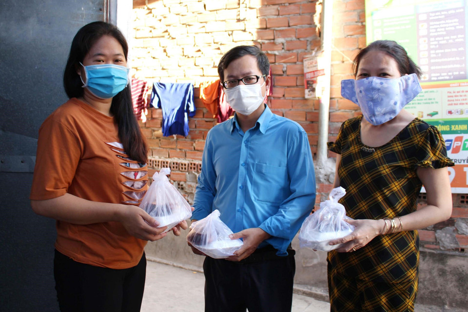 Lãnh đạo Liên đoàn Lao động quận 8 trao những suất cơm nghĩa tình công nhân đến tận tay người lao động có hoàn cảnh khó khăn tại các khu trọ. (Ảnh: Thanh Vũ/TTXVN)