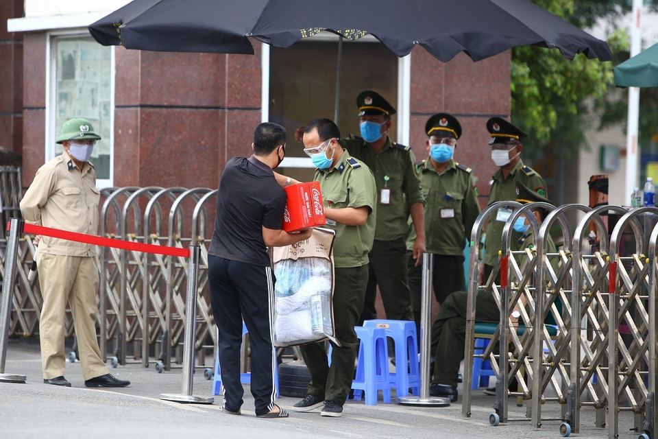 Người nhà mang gửi những đồ dùng thiết yếu cho người đang cách ly bên trong bệnh viện. (Ảnh: Minh Quyết/TTXVN)