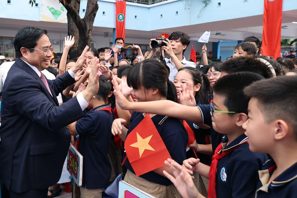 Học sinh Trường Tiểu học Đoàn Thị Điểm chào đón Thủ tướng Phạm Minh Chính. (Ảnh: Dương Giang/TTXVN)