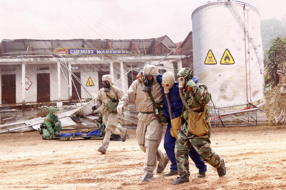 Lực lượng phòng hóa của Việt Nam cứu người dân bị ảnh hưởng của rò rỉ khí độc trong một tình huống giả định tại buổi diễn tập. (Ảnh: Phạm Kiên/TTXVN)