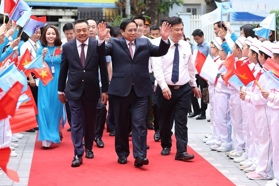 Các em học sinh Trường Tiểu học Đoàn Thị Điểm chào đón Thủ tướng Phạm Minh Chính và các đại biểu đến dự khai giảng. (Ảnh: Dương Giang/TTXVN)