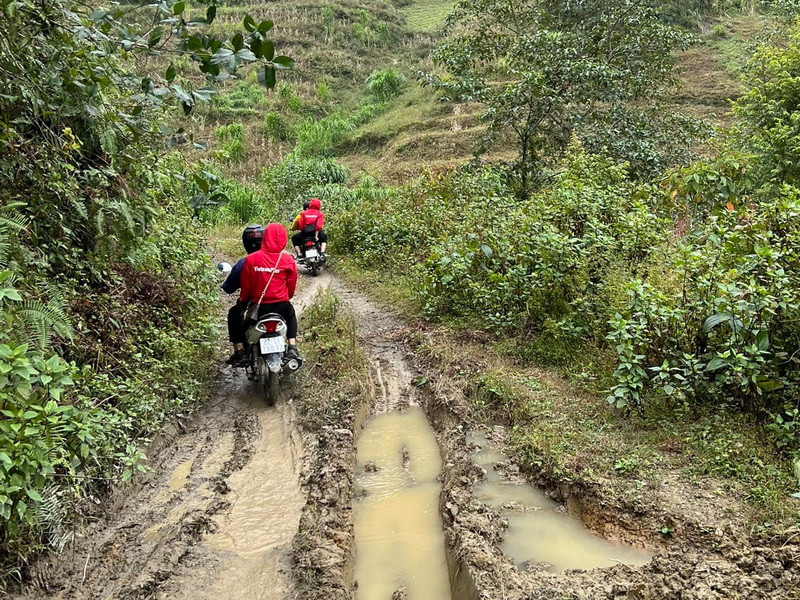 Sau những cơn mưa cuối Thu, nhiều đoạn đường sình lầy lội bùn... nhưng không làm khó được đoàn thiện nguyện...(Ảnh: PV/Vietnam+)