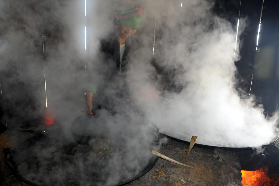 Trong khi nấu, nước mía được đảo cho sôi đều giữa các vạc đựng. (Ảnh: Nguyễn Công Hải/Vietnam+)