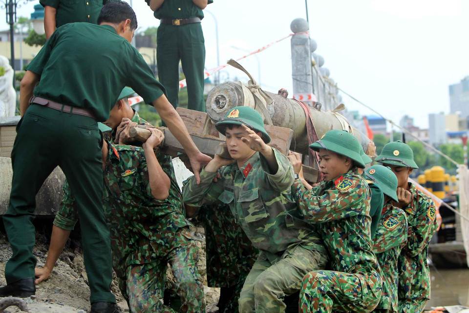 Các lực lượng chức năng di dời quả bom tại khu vực cầu mới sông Tam Bạc, khu vực phường Hạ Lý, quận Hồng Bàng tới nơi hủy nổ. (Ảnh: An Đăng/TTXVN)