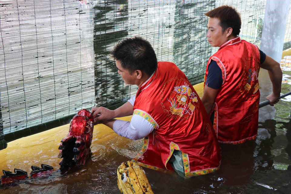 Các nghệ sỹ phường múa rối nước Đồng Ngư, xã Ngũ Thái (Thuận Thành, Bắc Ninh) chuẩn bị đạo cụ cho con rối trước khi biểu diễn. (Ảnh: Diệp Trương/TTXVN)