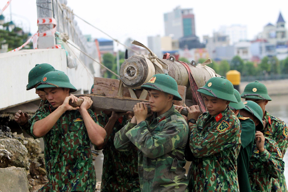 Các lực lượng chức năng di dời quả bom tại khu vực cầu mới sông Tam Bạc, khu vực phường Hạ Lý, quận Hồng Bàng tới nơi hủy nổ. (Ảnh: An Đăng/TTXVN)