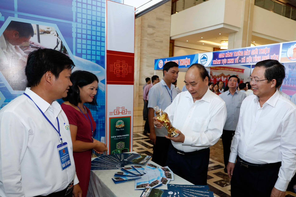 Thủ tướng Nguyễn Xuân Phúc thăm các gian hàng trưng bày tại hội nghị. (Ảnh: Thống Nhất/TTXVN)