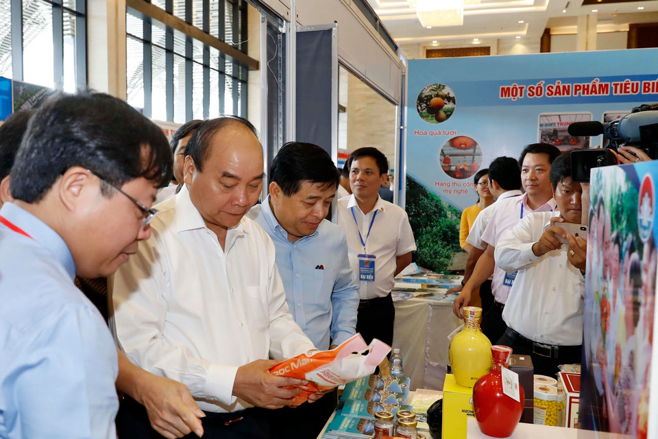 Thủ tướng Nguyễn Xuân Phúc thăm các gian hàng trưng bày tại hội nghị. (Ảnh: Thống Nhất/TTXVN)