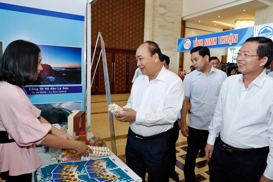 Thủ tướng Nguyễn Xuân Phúc thăm các gian hàng trưng bày tại hội nghị. (Ảnh: Thống Nhất/TTXVN)