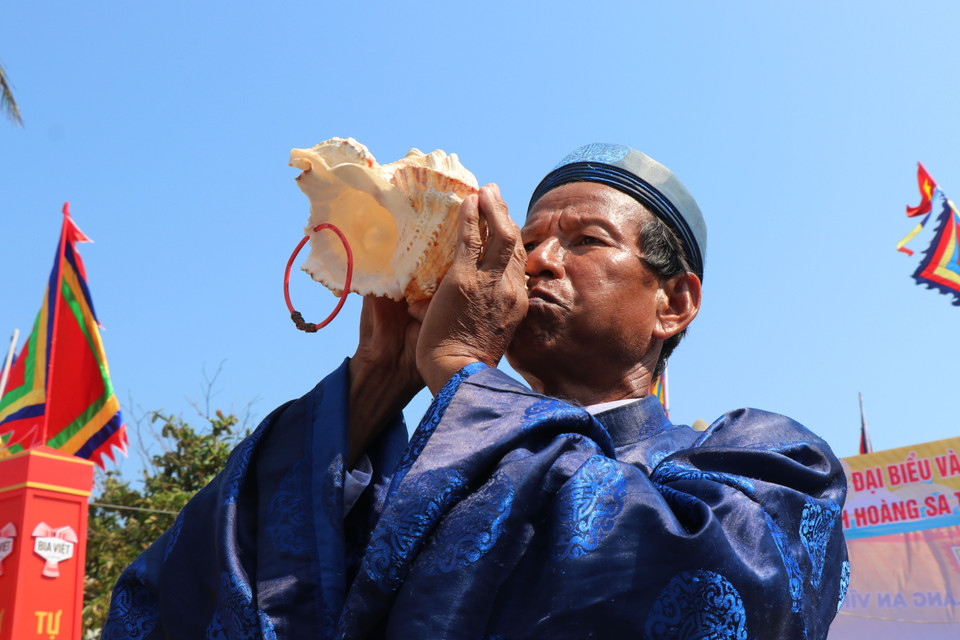 Thổi ốc u khi đưa các hình nhân thế mạng ra biển. (Ảnh: Phạm Cường/TTXVN)