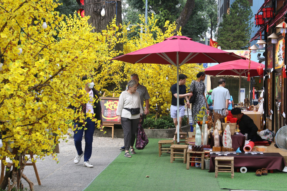 Một góc Phố ông đồ dọc theo mặt tiền đường Phạm Ngọc Thạch, Nguyễn Thị Minh Khai ngồi viết chữ cho khách ngày xuân. (Ảnh: Thanh Vũ/TTXVN)