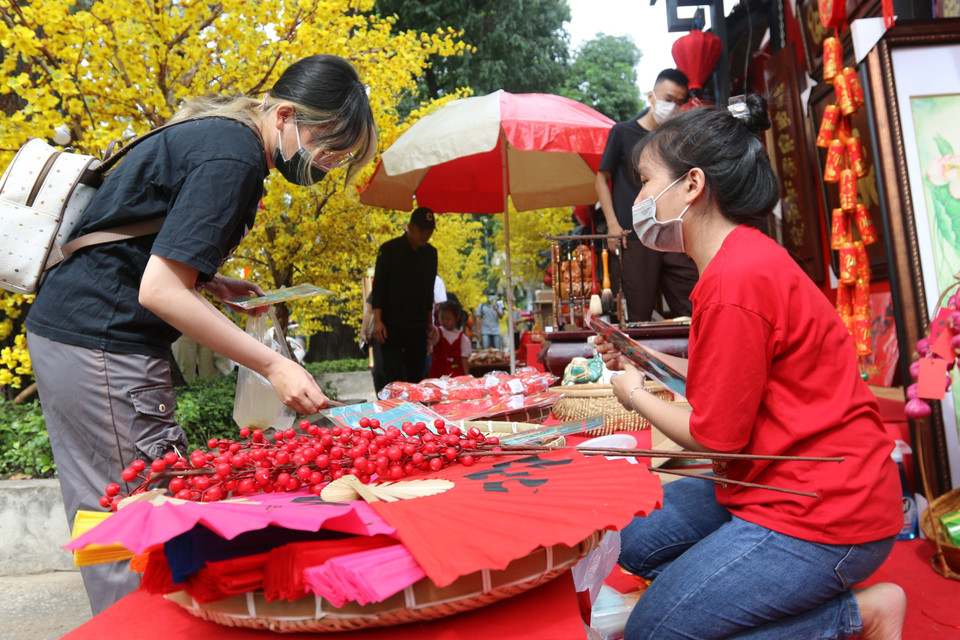 Khách tham quan mua sắm quà lưu niệm tại Phố ông đồ - Lễ hội Tết Việt Quý Mão năm 2023 tại Nhà văn hóa Thanh niên Thành phố Hồ Chí Minh. (Ảnh: Thanh Vũ/TTXVN)
