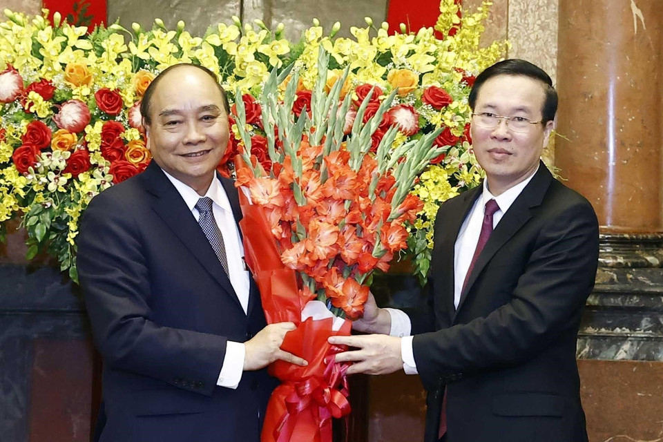 Đồng chí Võ Văn Thưởng, Ủy viên Bộ Chính trị, Thường trực Ban Bí thư tặng hoa nguyên Chủ tịch nước Nguyễn Xuân Phúc. (Ảnh: Thống Nhất/TTXVN)