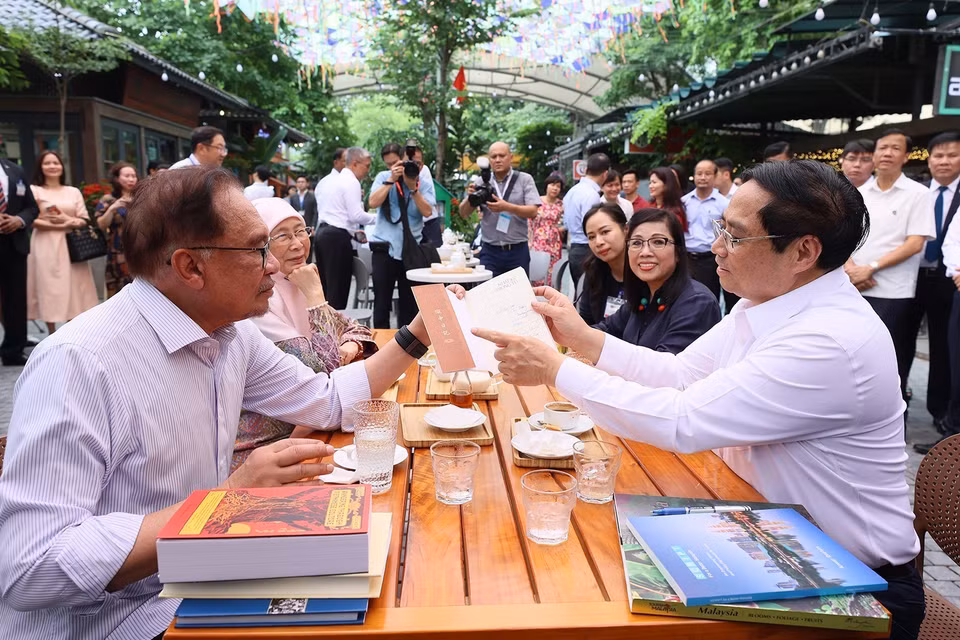 Thủ tướng Phạm Minh Chính tặng sách cho Thủ tướng Malaysia Anwar Ibrahim và Phu nhân. (Ảnh: Dương Giang/TTXVN)