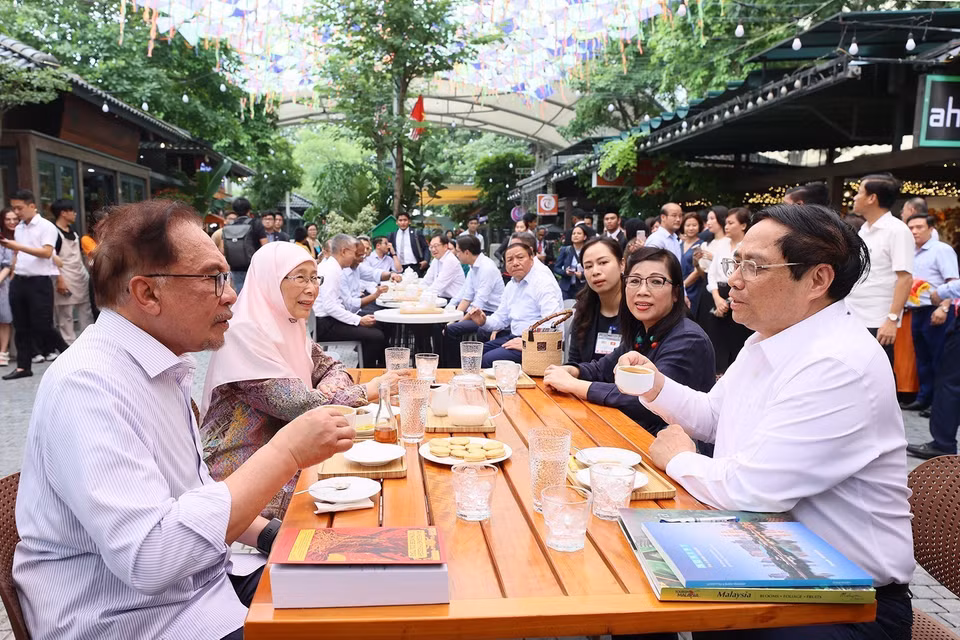 Thủ tướng Phạm Minh Chính và Phu nhân cùng Thủ tướng Malaysia Anwar Ibrahim và Phu nhân thưởng thức càphê tại Phố sách Hà Nội. (Ảnh: Dương Giang/TTXVN)