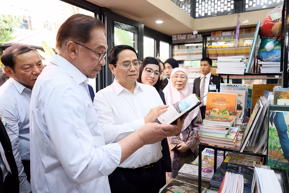 Thủ tướng Phạm Minh Chính và Thủ tướng Malaysia Anwar Ibrahim xem sách tại Phố sách. (Ảnh: Dương Giang/TTXVN)