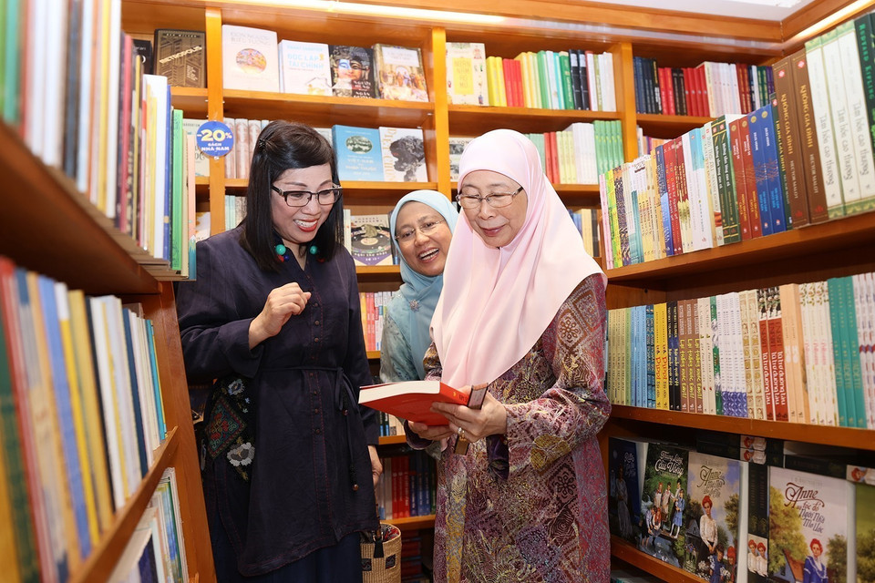Bà Lê Thị Bích Trân, Phu nhân Thủ tướng Phạm Minh Chính và bà Dato’ Seri Dr. Wan Azizah binti Dr. Wan Ismail, Phu nhân Thủ tướng Anwar Ibrahim xem sách. (Ảnh: Dương Giang/TTXVN)
