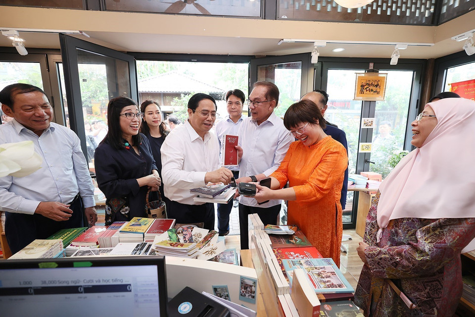 Thủ tướng Phạm Minh Chính mua sách tặng Thủ tướng Malaysia Anwar Ibrahim và Phu nhân. (Ảnh: Dương Giang/TTXVN)