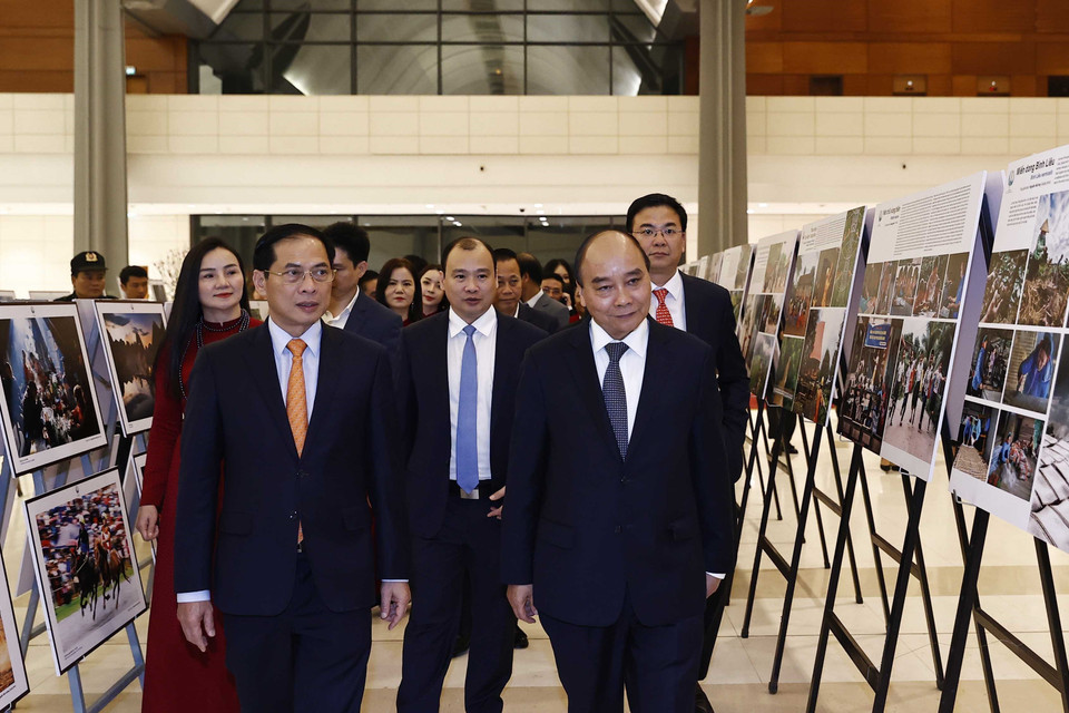 Chủ tịch nước Nguyễn Xuân Phúc xem trưng bày ảnh tại Chương trình Xuân Quê hương năm 2023. (Ảnh: Thống Nhất/TTXVN)