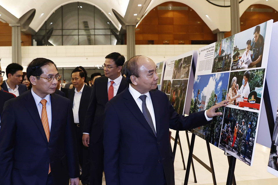 Chủ tịch nước Nguyễn Xuân Phúc xem trưng bày ảnh tại Chương trình Xuân Quê hương năm 2023. (Ảnh: Thống Nhất/TTXVN)