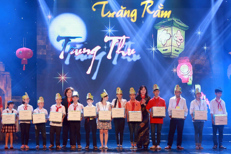 Các tập thể, cơ quan trao học bổng cho các em có hoàn cảnh khó khăn vươn lên trong học tập. (Ảnh: Nguyễn Quang/TTXVN)