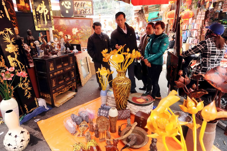 Đến chợ hoa Hàng Lược, ngoài hoa tươi, người ta còn có thể tìm mua được cả một số loại hoa giả nghệ thuật hay những món đồ cổ về trang trí gian phòng trong dịp Tết. (Ảnh: Minh Đức/TTXVN) 