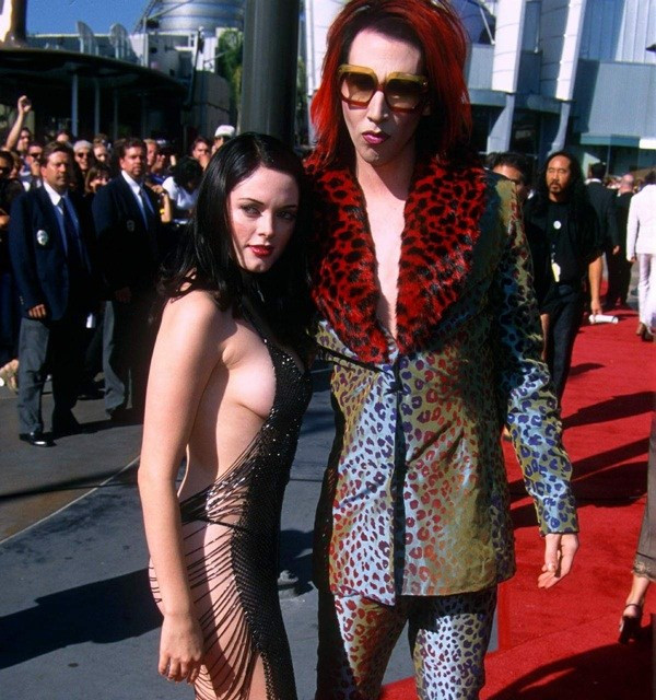 Trong khi bạn trai Marilyn Manson (phải) cố ăn mặc lòe loẹt nhất có thể thì cô đào Rose McGowan lại... chẳng cần mặc gì nhiều mà vẫn thu hút mọi ánh nhìn trên thảm đỏ tại lễ trao giải MTV 1998.