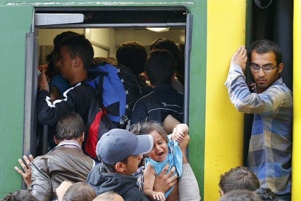 Những người di cư, bao gồm cả trẻ nhỏ, đều cố lên tàu với hy vọng tới nước Đức. (Nguồn: Dailymail)