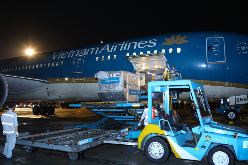 Lô hàng vaccine, thiết bị và vật tư y tế phòng, chống dịch COVID-19 được chuyển từ chuyên cơ Chủ tịch nước xuống phương tiện vận chuyển. (Ảnh: Nguyễn Điệp/TTXVN)