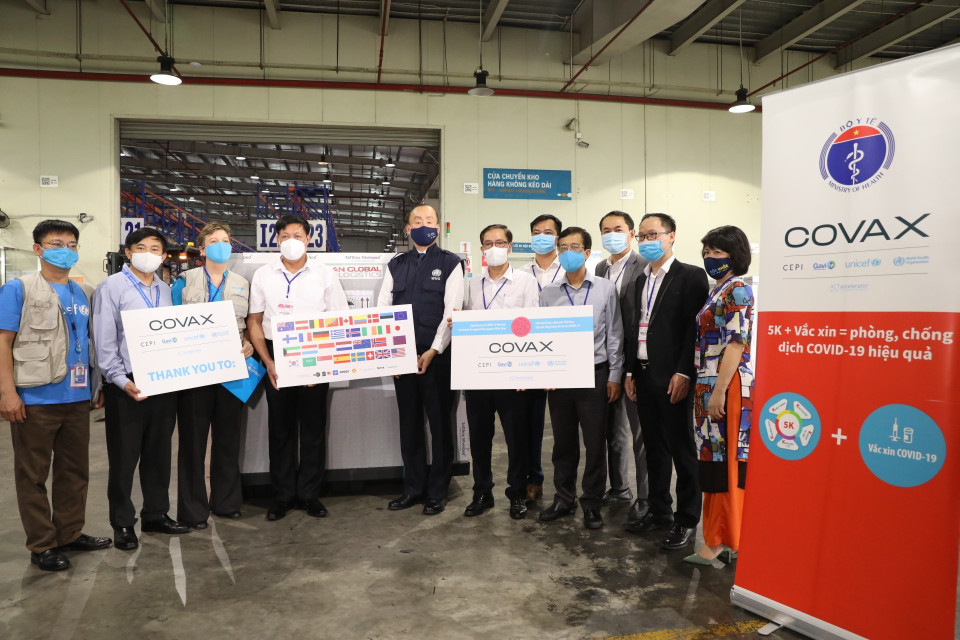 Thứ trưởng Bộ Y tế Đỗ Xuân Tuyên, Trưởng Đại diện Tổ chức Y tế Thế giới tại Việt Nam Kydong Park và các đơn chị chức năng nhận lô vaccine đầu tiên từ COVAX Facility. (Ánh: Minh Quyết/TTXVN)