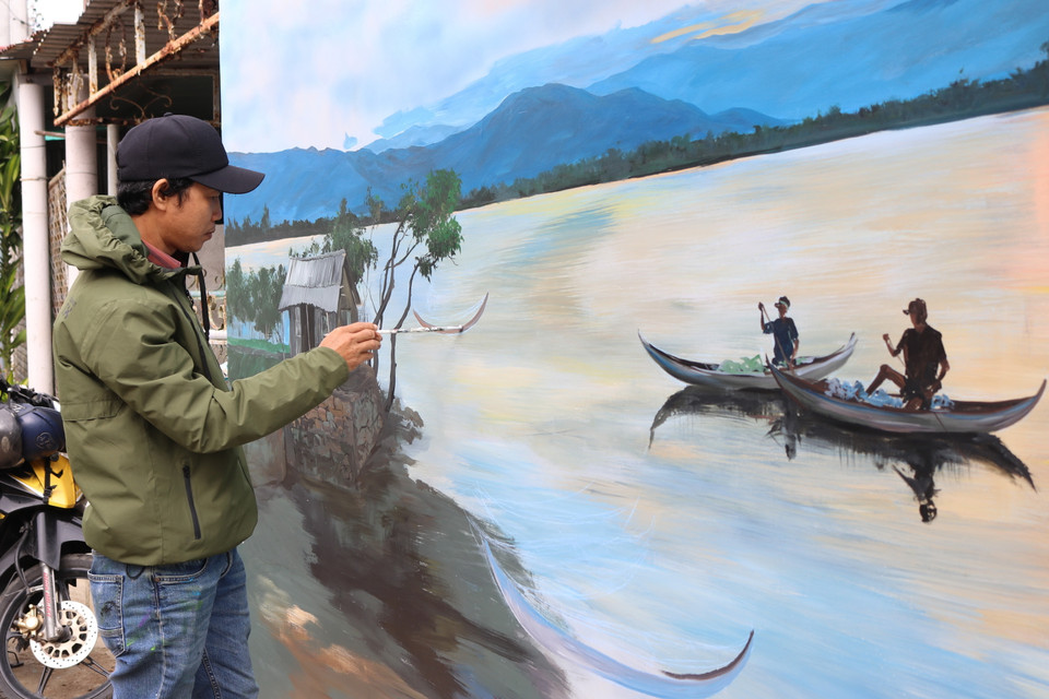 Họa sỹ vẽ bức tranh với khung cảnh thanh bình của làng Hòn Thiên. (Ảnh: Nguyễn Thành/TTXVN)